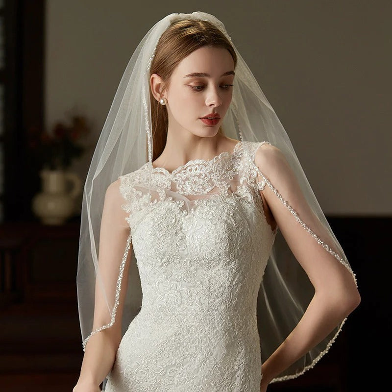 Elegant beaded hair comb with delicate mid-length tulle bridal veil handcrafted from soft chiffon