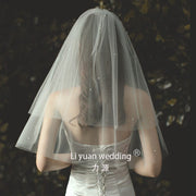 Beaded lace trim bridal veil with bow accent on soft tulle fabric