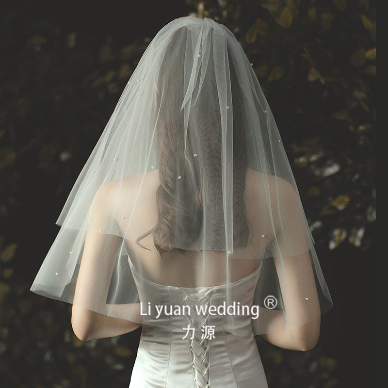 Beaded lace trim bridal veil with bow accent on soft tulle fabric