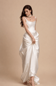 Elegant ivory satin corset gown with pearl accents and flowing floor-length skirt for bridal elegance