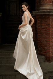 Ivory satin corset gown with pearl accents and flowing silhouette for bridal elegance