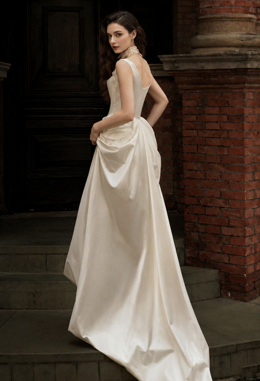 Ivory satin corset gown with pearl accents and flowing silhouette for bridal elegance
