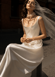Ivory satin corset gown with pearl accents and flowing floor-length skirt for bridal elegance