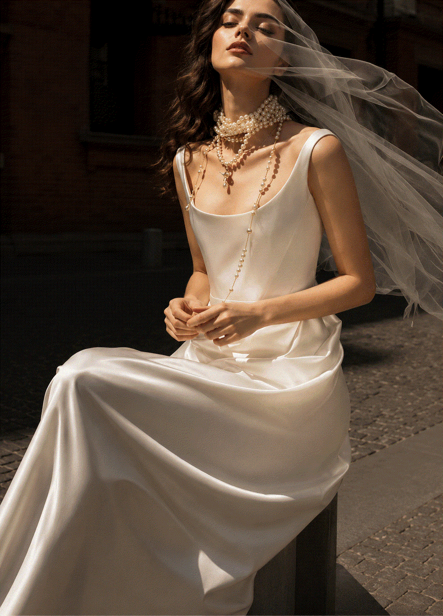 Ivory satin corset gown with pearl accents and flowing floor-length skirt for bridal elegance