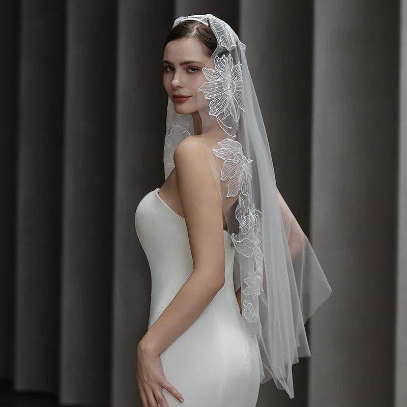 Dramatic lace bridal veil made of soft chiffon tulle with a long, semi-sheer design and hair tie.