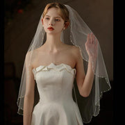 Lace trim bridal veil with soft tulle and delicate comb for mid-length wedding headpiece
