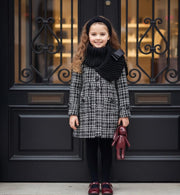 Young girl wearing elegant red cashmere long coat with black bow detail for autumn and winter.