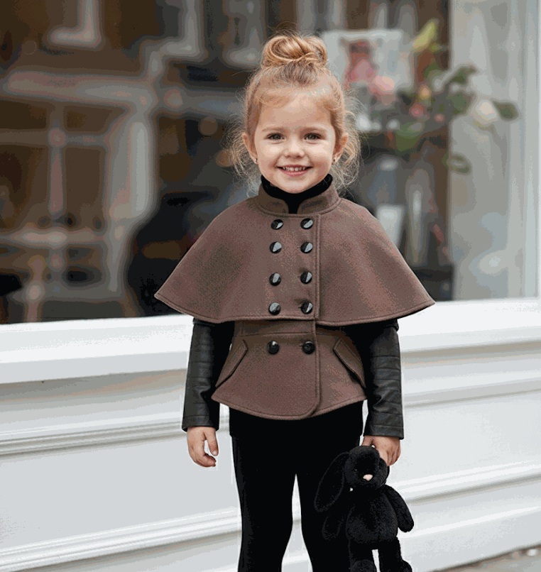 Girl wearing black wool cape coat baby doll style winter outerwear for ages 4 to 7 years
