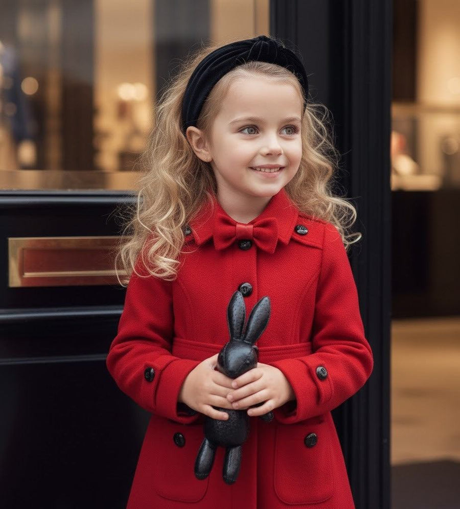 Girl wearing elegant red cashmere long coat with black bow detail for autumn winter ages 3-5 years