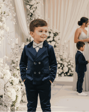 young boy wearing boys navy velvet suit set with blazer and trousers for formal occasions