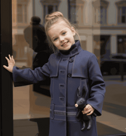 Girl wearing a stylish high-neck autumn winter coat for ages 3-10 with two fabric options