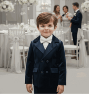 young boy wearing boys navy velvet suit set with blazer and trousers for wedding or formal occasion