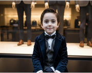 Boy aged 6-9 wearing a tailored navy velvet blazer, styled for formal and everyday occasions with classic lapels and soft texture.