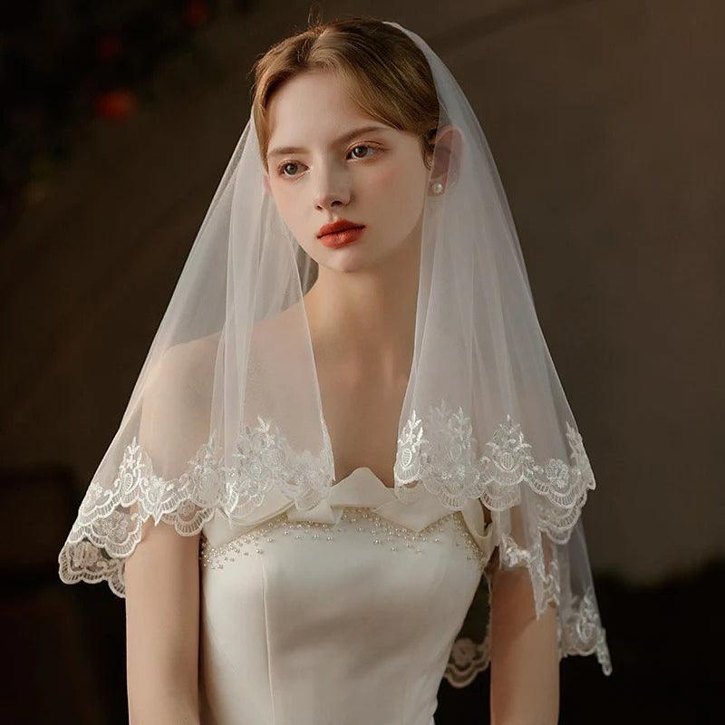 Pearl lace hair comb attached to a mid-length sheer bridal veil made of soft chiffon tulle