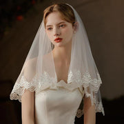 Pearl lace hair comb attached to a mid-length sheer bridal veil made of soft chiffon tulle