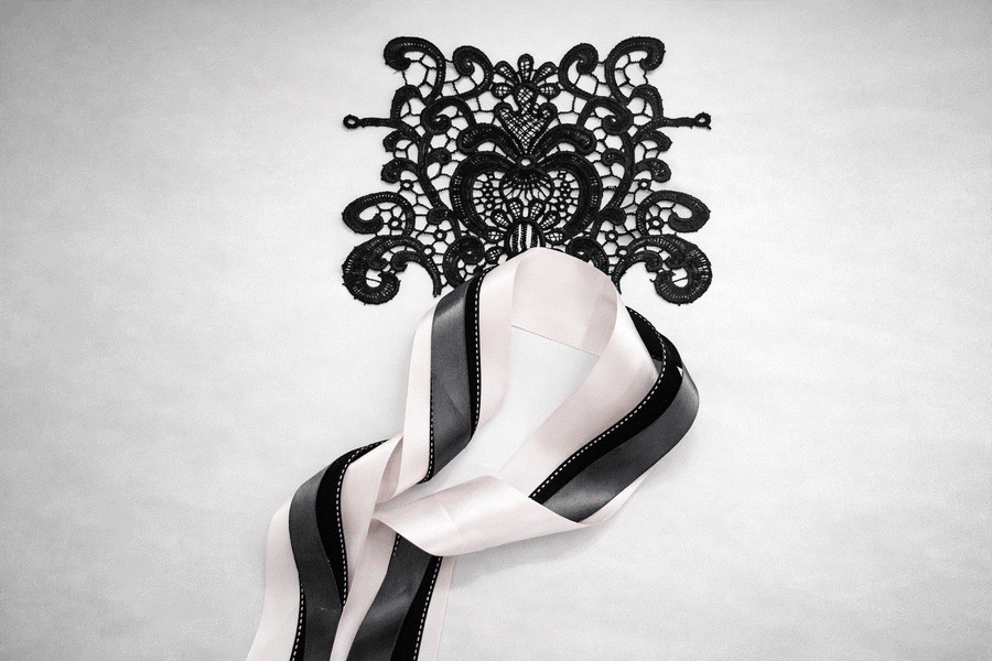 Blush structured lace set with black textured and grey layered ribbons featuring floral lace applique for elegant wedding decor and styling