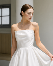 Elegant satin strapless wedding dress with sculpted bodice and full skirt in minimalist bridal design