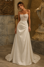 Ivory satin draped strapless wedding dress with lace corset and cathedral train on model