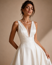 Ivory satin wedding guest dress with deep V-back and sculpted waist pleating