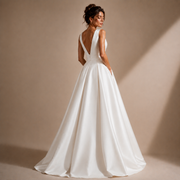 Ivory satin deep V-back wedding guest dress with sculpted waist pleating and flowing skirt