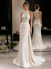 Back view of an ivory lace halter dress with elegant backless design and draped train on a mannequin