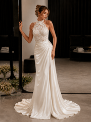 Ivory lace halter dress with backless design and draped train for elegant wedding guest look