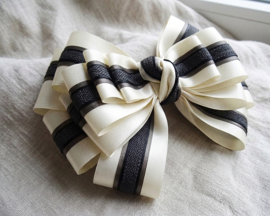 Ivory and charcoal satin ribbons styled in elegant bows for weddings and gifts