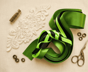 Set of three emerald green satin ribbons with varying textures and widths for elegant styling and gift wrapping