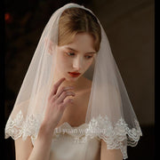 Pearl lace hair comb with mid-length sheer wedding veil in soft chiffon tulle