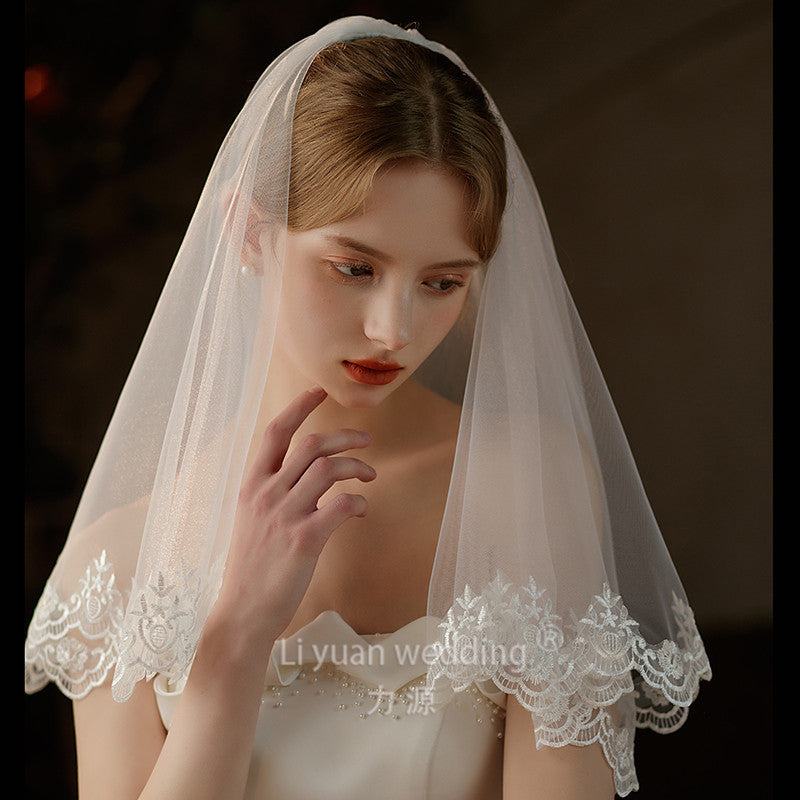 Pearl lace hair comb with mid-length sheer wedding veil in soft chiffon tulle