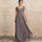 Chiffon long evening gown in dusty gray with lace appliqué bodice, short sleeves, V-neckline, and flowing skirt design.