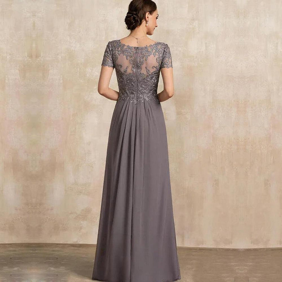 Chiffon long evening gown in muted grey with lace short sleeves and sheer embroidered back panel, flowing skirt design.