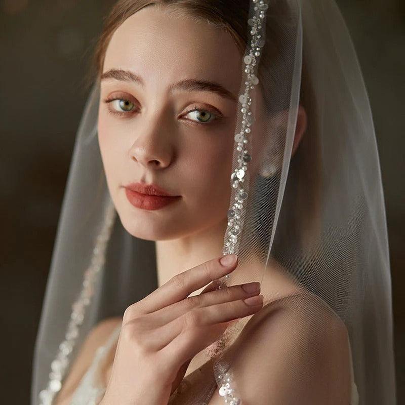 Handmade beaded metal comb securing a mid-length soft chiffon bridal veil