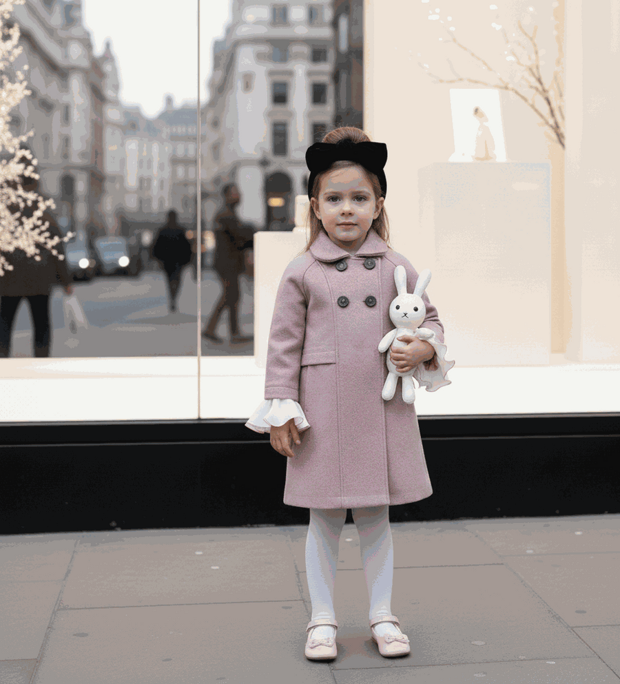 Girls' Woolen Winter coat in dusty pink wool, with a long double-breasted design, dark buttons, and white ruffled cuffs.