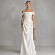 Ivory satin off-shoulder corset wedding guest dress with elegant draped waist and flowing silhouette