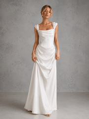 Ivory satin off-shoulder corset wedding guest dress with draped waist and flowing skirt