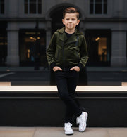 Kids' Velvet Blazer in dark olive green with a soft matte finish, featuring an asymmetrical zip, snap details and hooded collar.