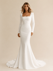 Mermaid wedding dress in white crepe with a square neckline, long sleeves, and a fitted silhouette flaring into a train